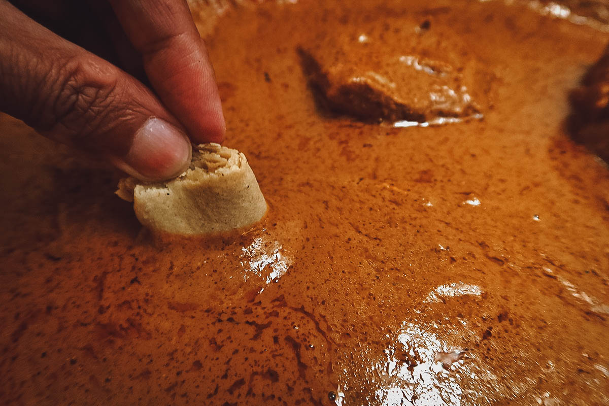 The Best Pipian in Puebla Dunking corn tortilla in pipian rojo in Puebla